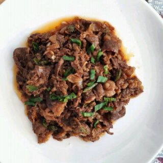 Spicy Korean Beef Stir Fry garnished with spring onion in a plate
