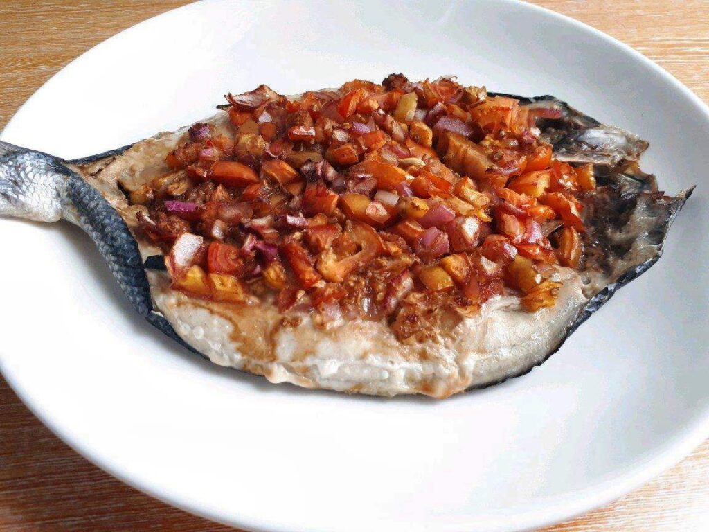 Baked Bangus (Milkfish) topped with ginger, tomatoes and red onion.