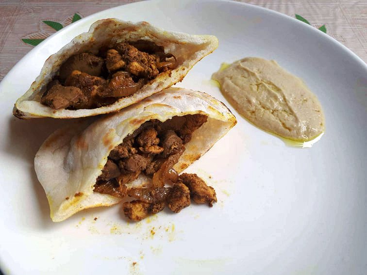 Jerusalem Mixed Grill Sandwich in a Pita bread serve with Hummus sauce in a plate