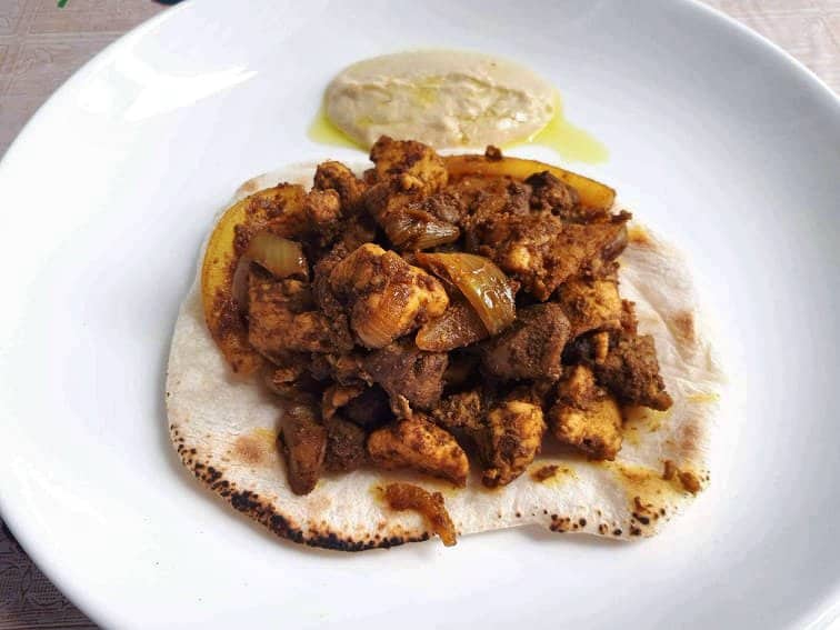 Jerusalem Mixed Grill serve above the Pita bread and serve with Hummus sauce in a plate