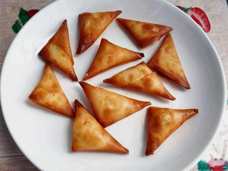 10 pieces of cheese samosas in a plate.