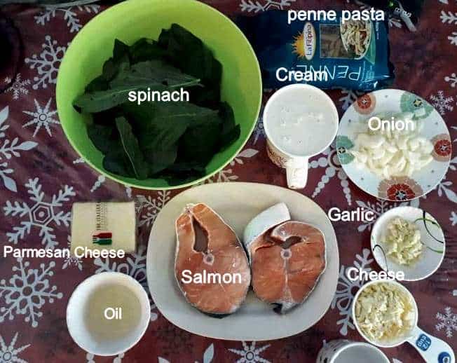 Recipe ingredients of Salmon Alfredo Pasta which includes Spinach Leaves, Parmesan & cheddar cheese, chopped onion & garlic, light cream, vegetable oil and uncooked penne pasta