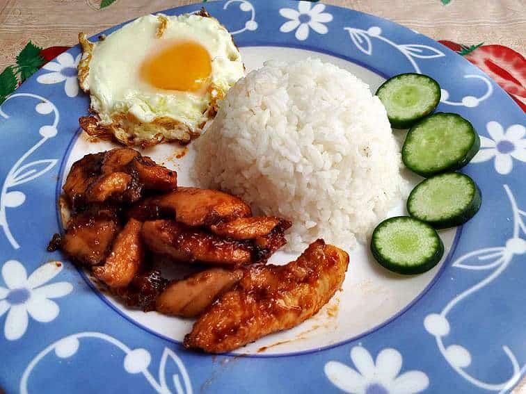 Chicken Tocino served with white rice, sunny-side up egg and sliced cucumber.