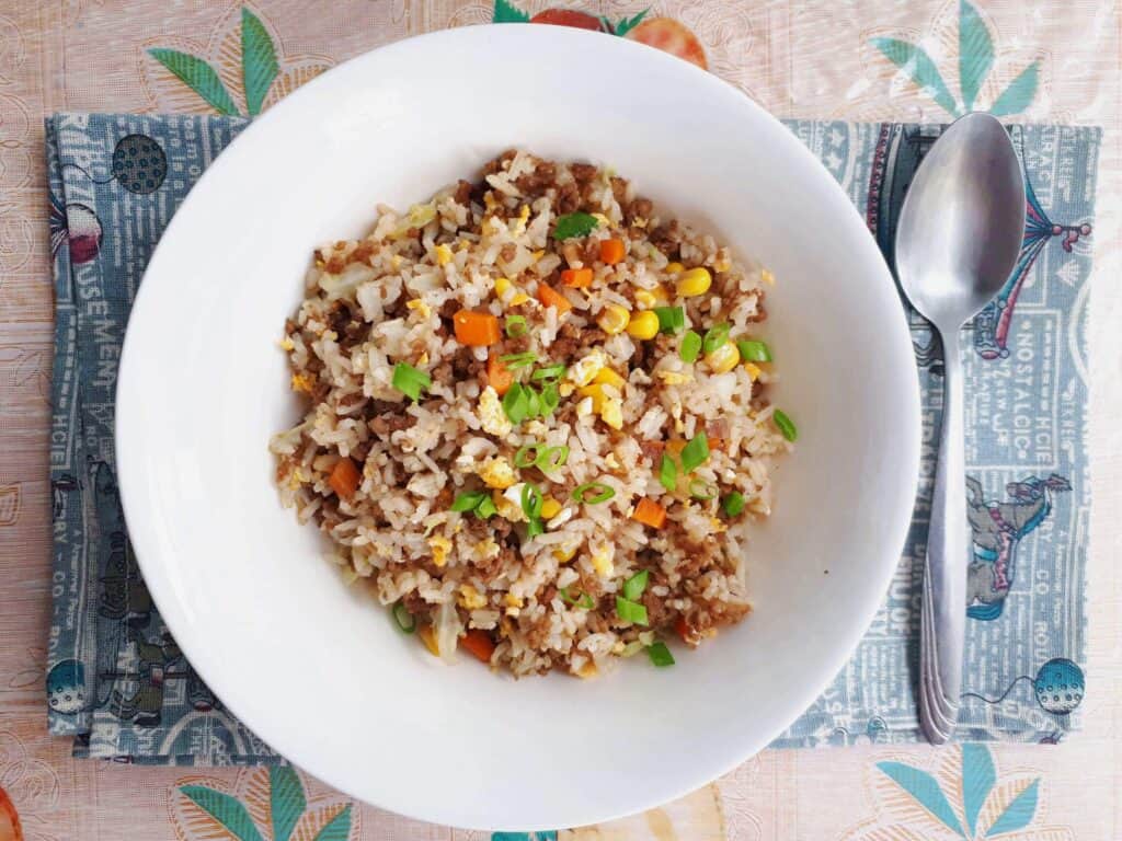 Beef Chao Fan recipe mixed with ground beef, carrots, cabbages, spring onion, eggs and rice serve on a plate bowl.