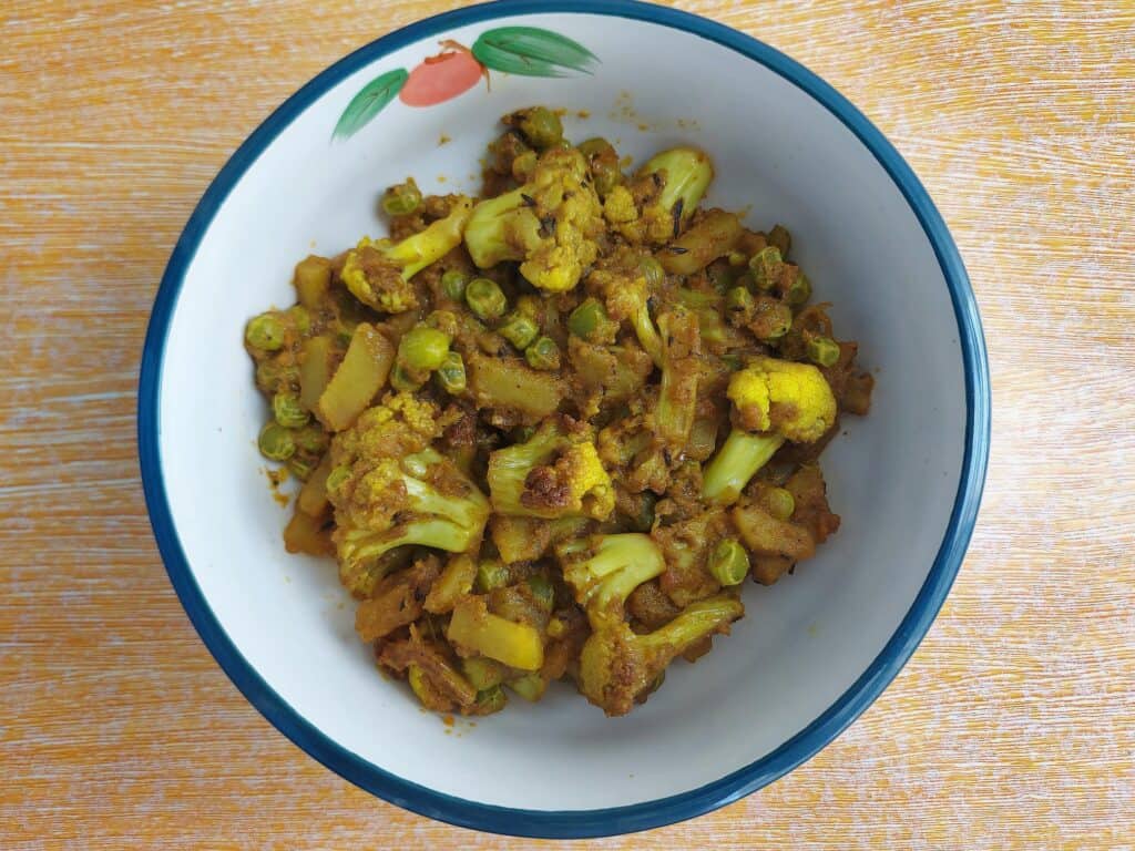 Indian Cauliflower Potato and Green Pea Curry called Aloo Gobi Matar served on a plate bowl 