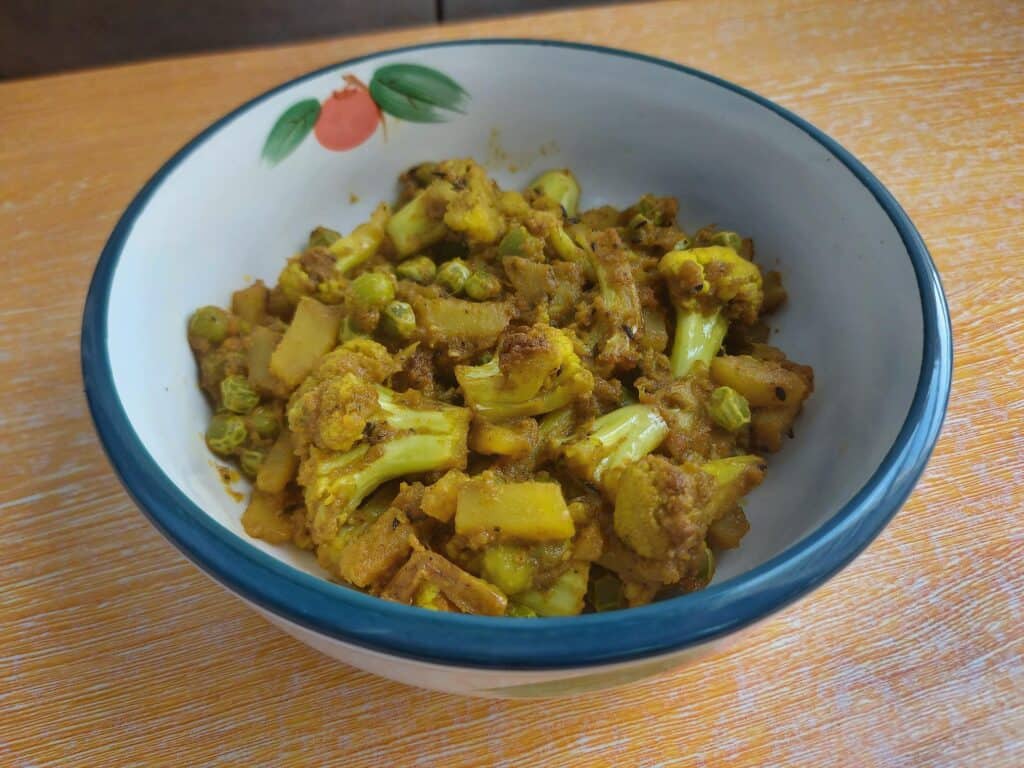 Indian Cauliflower Potato and Green Pea Curry called Aloo Gobi Matar served on a plate bowl