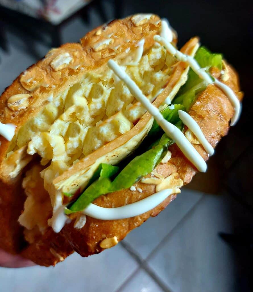 Korean Egg Drop Sandwich with fillings of scrambled egg, ham, cheese, lettuce and drizzle with sweet mayonnaise sauce served on a butter toasted bread