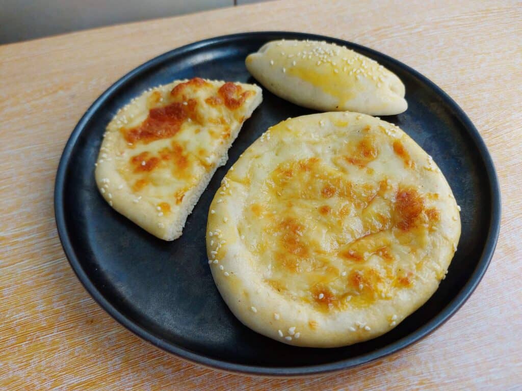 A Middle Eastern round cheese flatbread recipe called Cheese Manakish serve on a plate