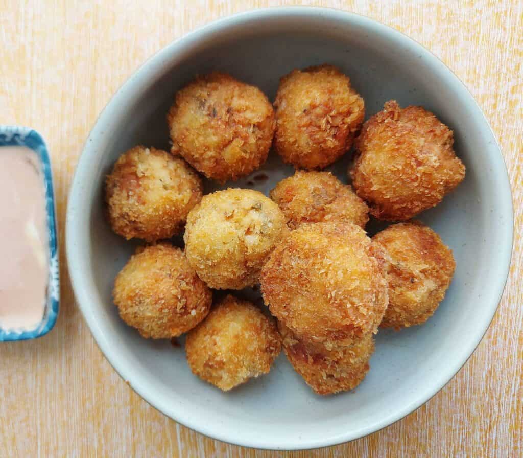 Chicken nugget with cheese with one slices open served on a plate