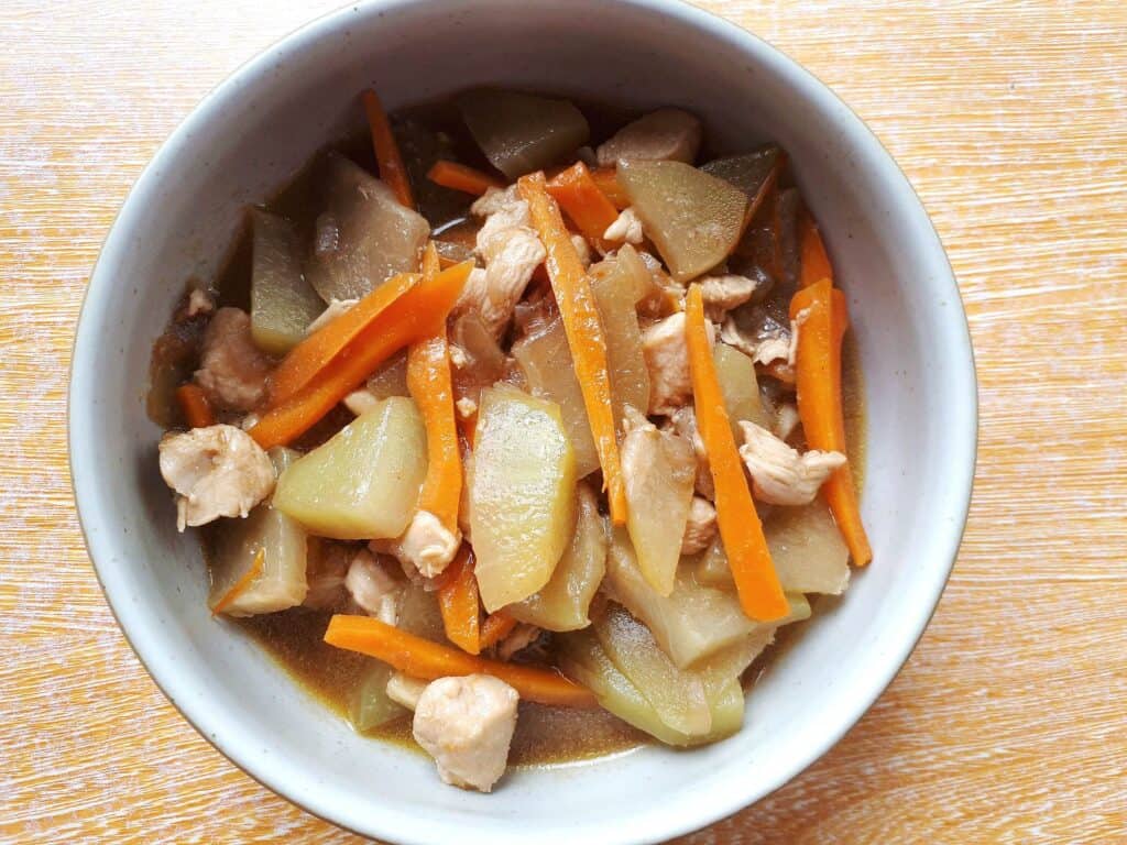 Filipino Chayote recipe Ginisang Sayote with julienned carrot and chopped chicken breast served on a plate bowl