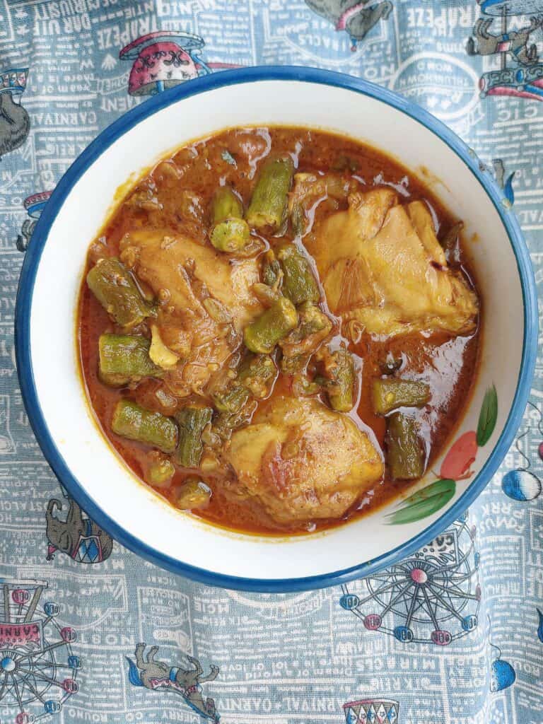 Chicken Bhindi with okra, chicken thigh, tomato gravy sauce serve on a plate bowl.
