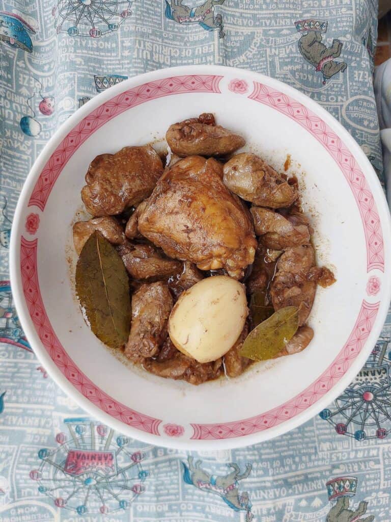 Chicken Liver Adobo recipe called Adobong Atay serve with chicken thigh, boiled egg and liver with bay leaves served on a plate bowl.