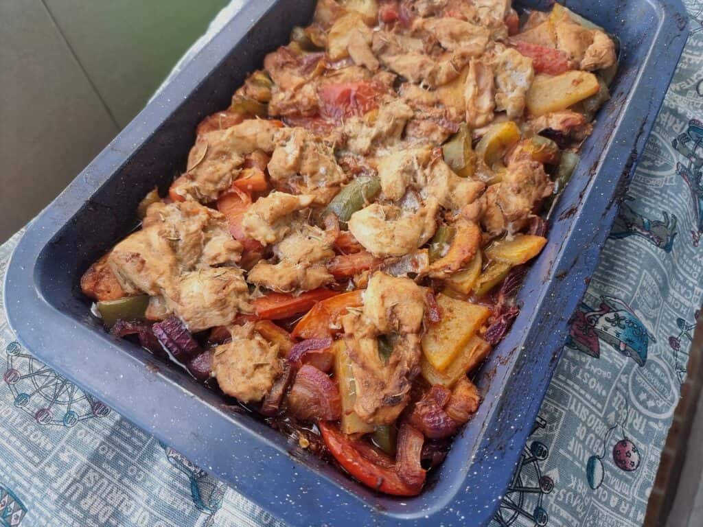 Turkish Chicken Tava (Tavuk Tava) mixed with potatoes, bell pepper, tomatoes, marinated chicken and different herbs & spices served on a baking tray