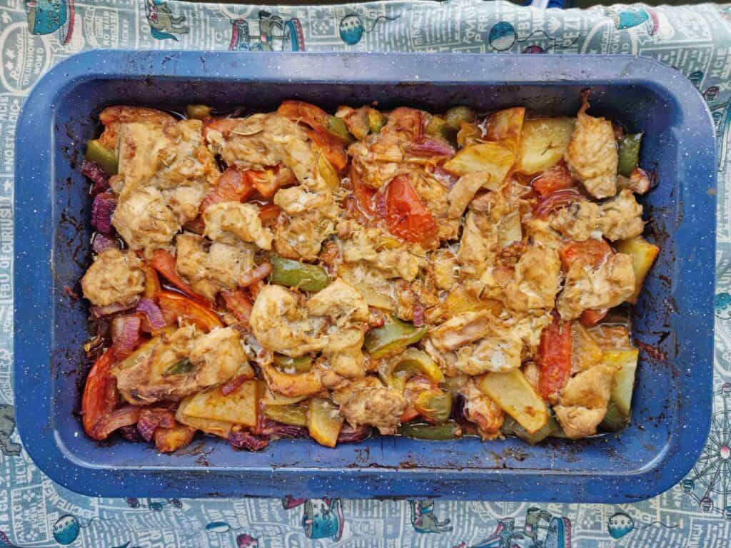 Turkish Chicken Tava (Tavuk Tava) mixed with potatoes, bell pepper, tomatoes, marinated chicken and different herbs & spices served on a baking tray