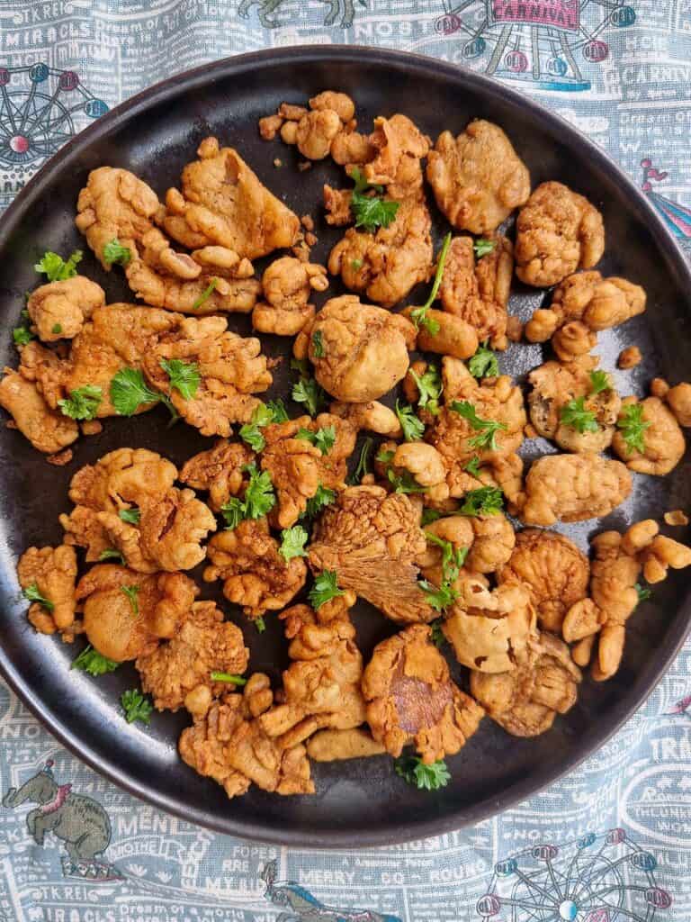 A Filipino vegetarian snack Mushroom chicharon made by thinly slicing, seasoning, and deep-frying mushrooms to achieve a crispy texture