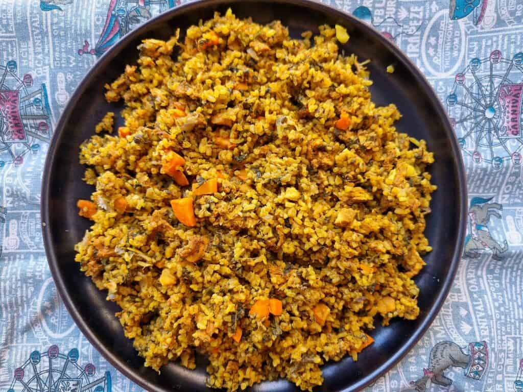Tunisian recipe Rouz Jerbi (Djerbian rice) mixed with chopped chicken, carrots, chopped green leaves, rice with different aromatic spices on a plate