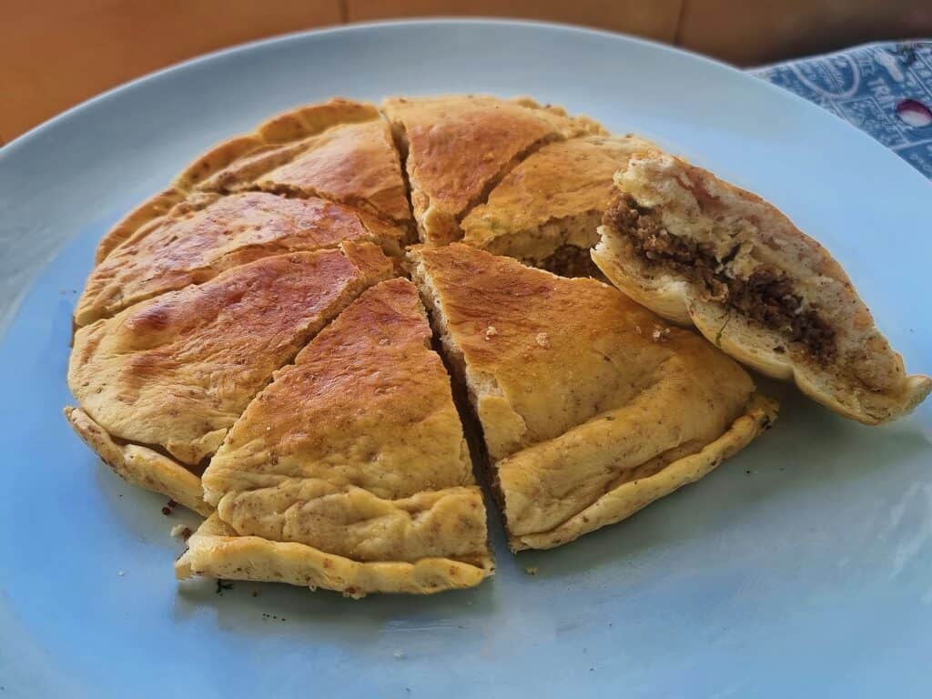 Moroccan Berber pizza medfouna with ground meat filling served in a plate.