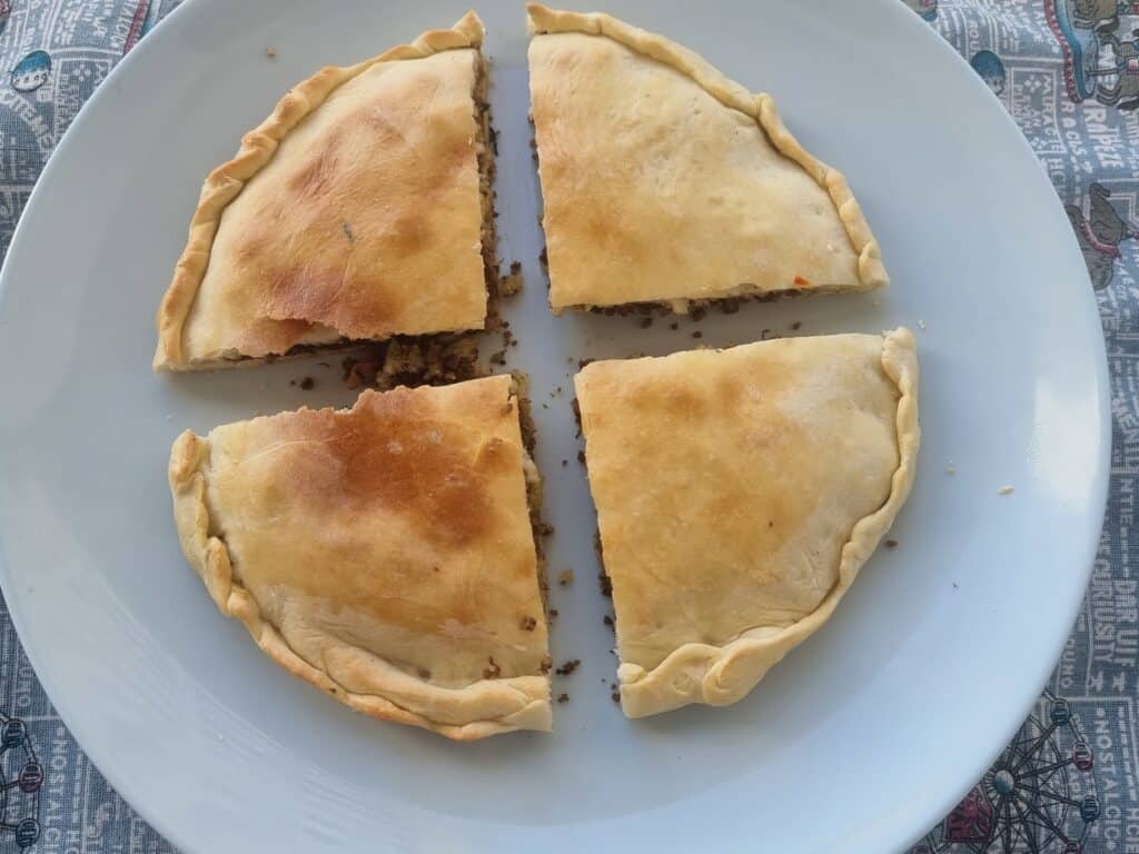 Moroccan Berber pizza medfouna with ground meat filling served in a plate.