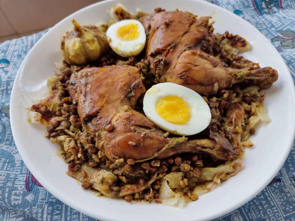 Moroccan Chicken lentils Rfissa served with boiled egg and msemmen bread on a plate.