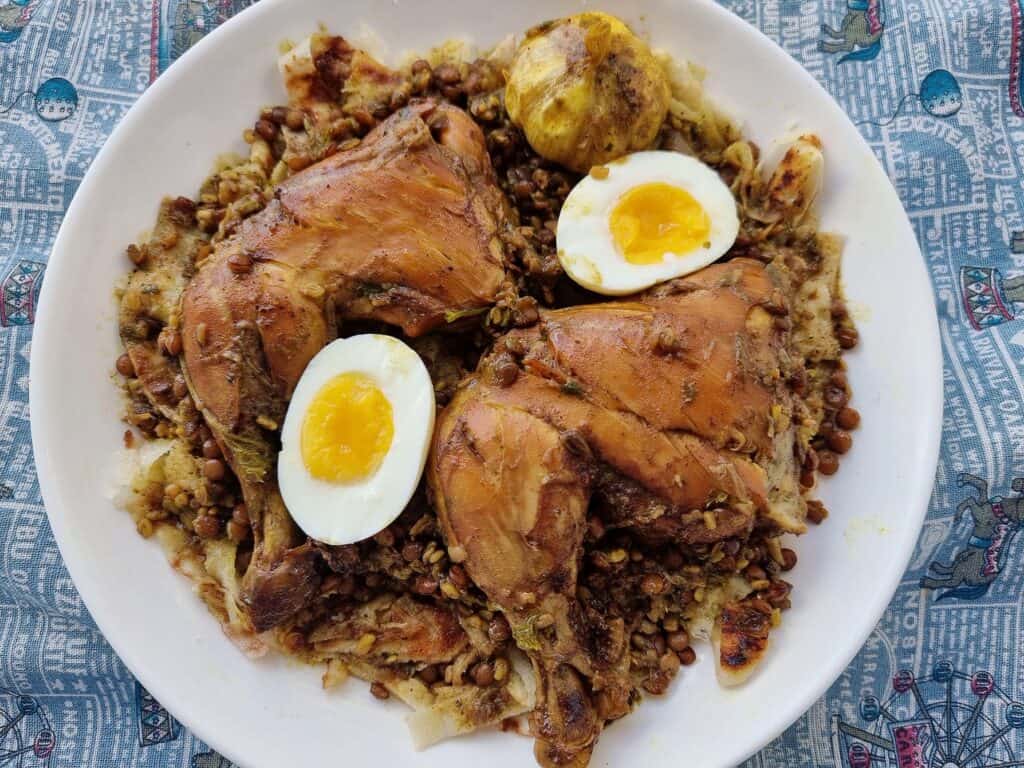 Moroccan Chicken lentils Rfissa served with boiled egg and msemmen bread on a plate.