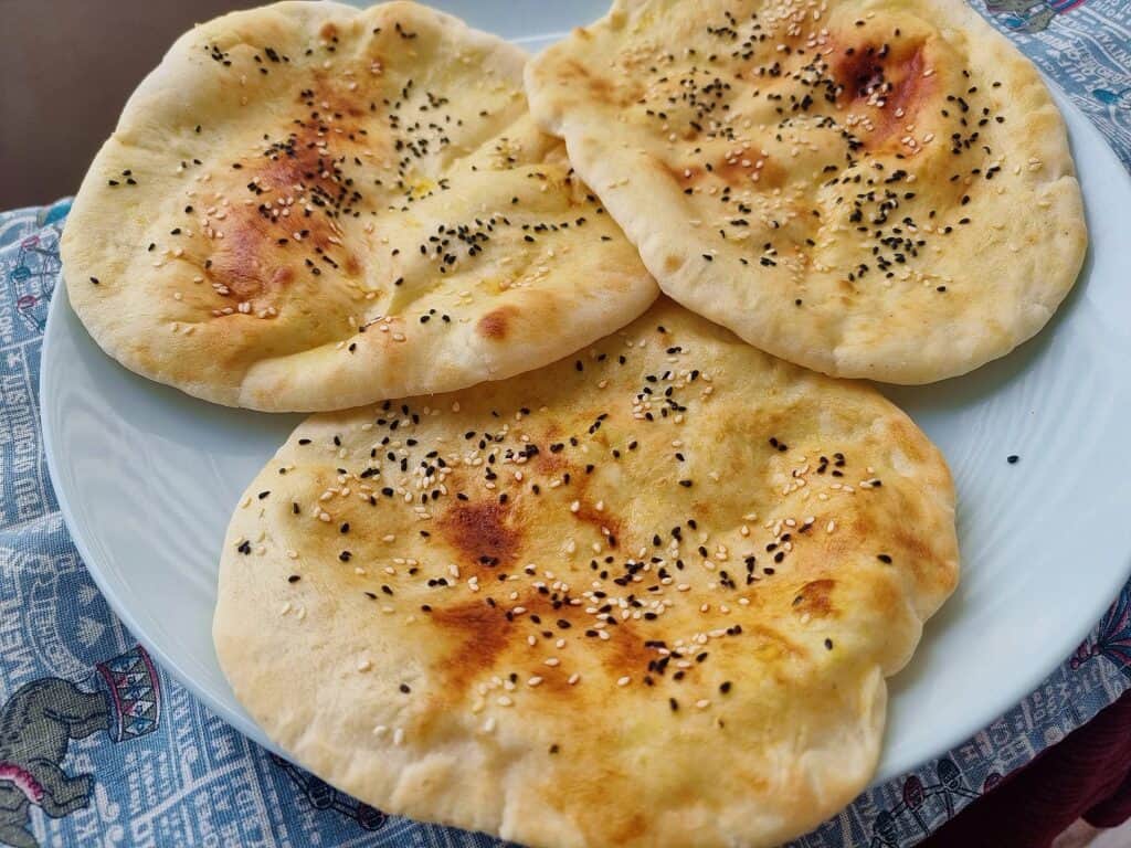 Emirati flatbread Khameer topped with sesame seeds and black cumin seeds serve on a plate