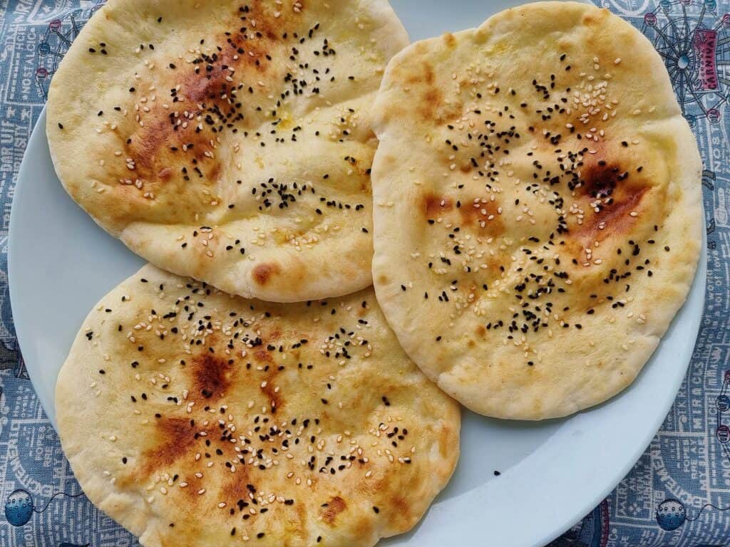 Emirati flatbread Khameer topped with sesame seeds and black cumin seeds serve on a plate