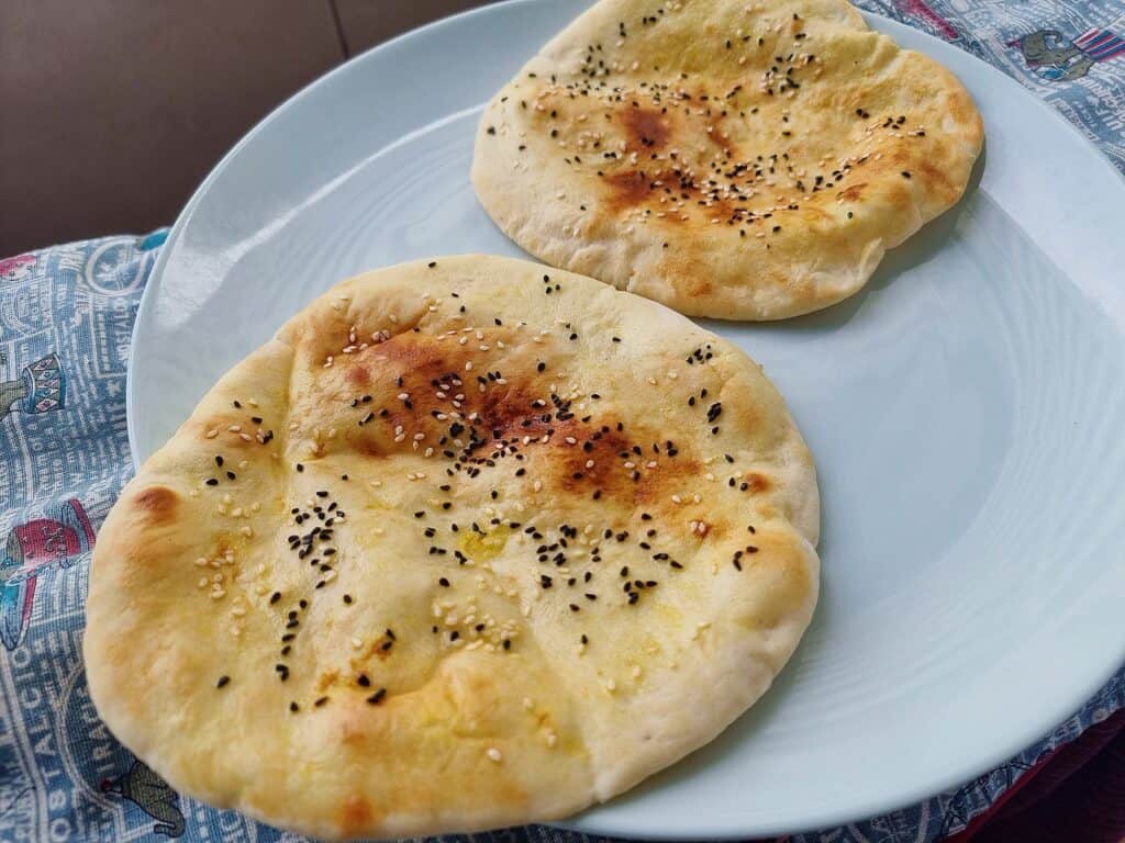 Emirati flatbread Khameer topped with sesame seeds and black cumin seeds serve on a plate