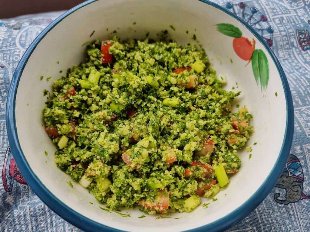 A colorful Moroccan Tabbouleh Salad, a vegetarian dish featuring couscous, tomatoes, parsley, and spring onion, seasoned with lemon juice and olive oil.