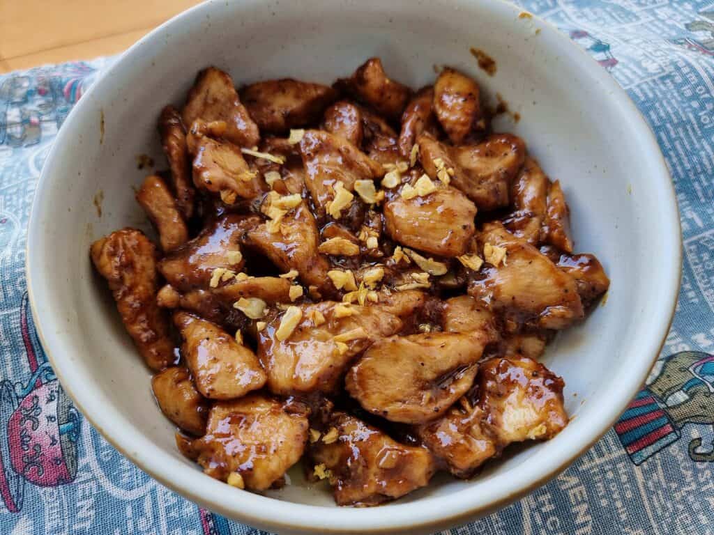 Thai Garlic Pepper Chicken pad Kra Tiem sprinkle with fried garlic served on a plate