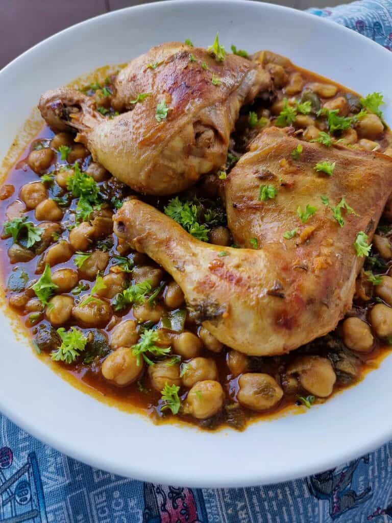 Algerian dish Chtitha Djedj with chicken leg quarters & chickpeas garnished with chopped parsley